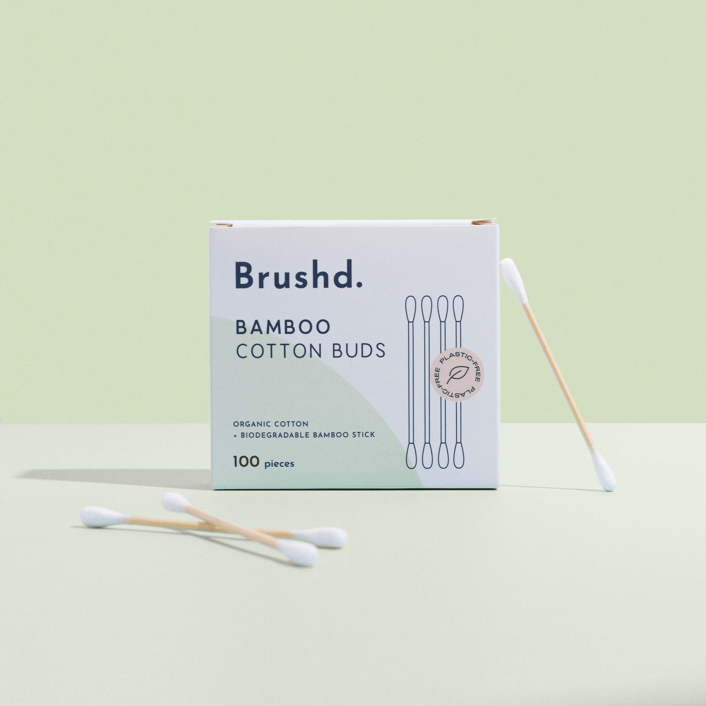 bamboo cotton ear buds by brushd upright on green background