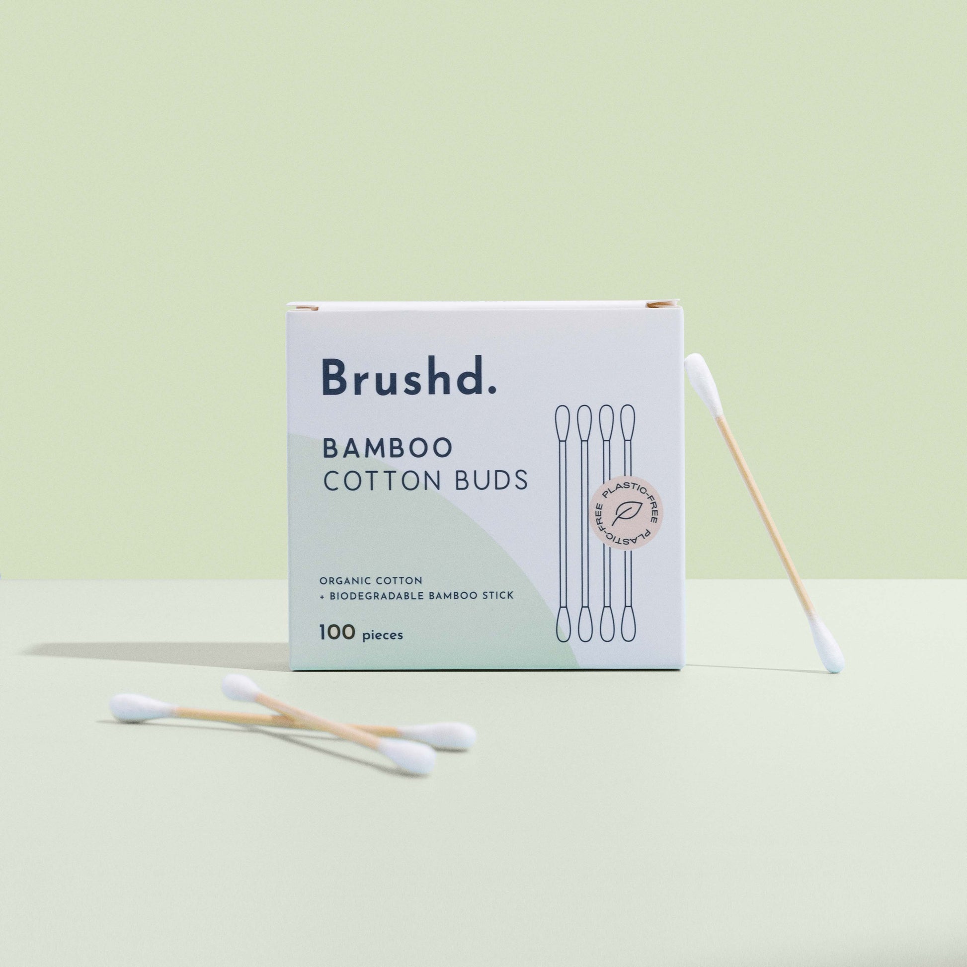 bamboo cotton ear buds by brushd  upright on green background
