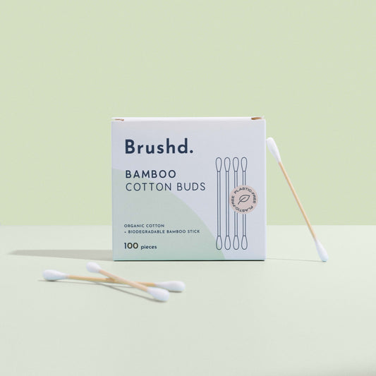 bamboo cotton ear buds by brushd upright on green background