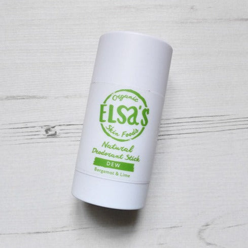 dew deodorant deo stick by elsa, white wooden background, birds eye view