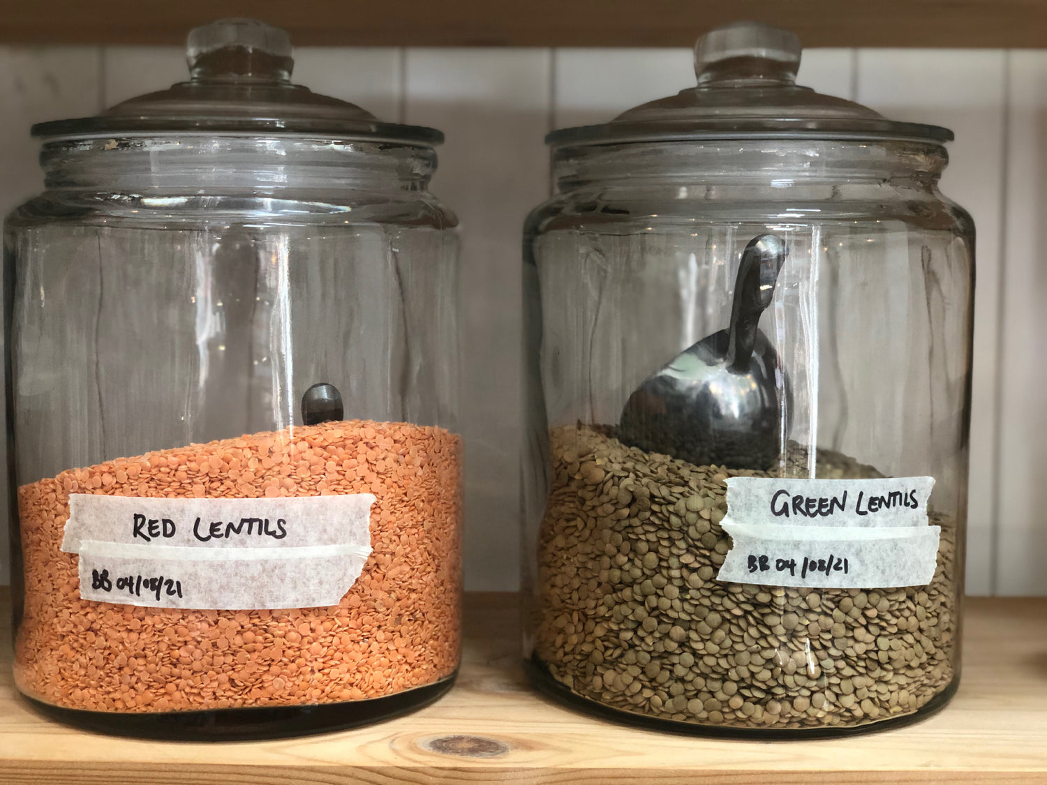 large bulk food jars with silver scoops, green red lentils in zero wast shop brixton, weigh and pay refill