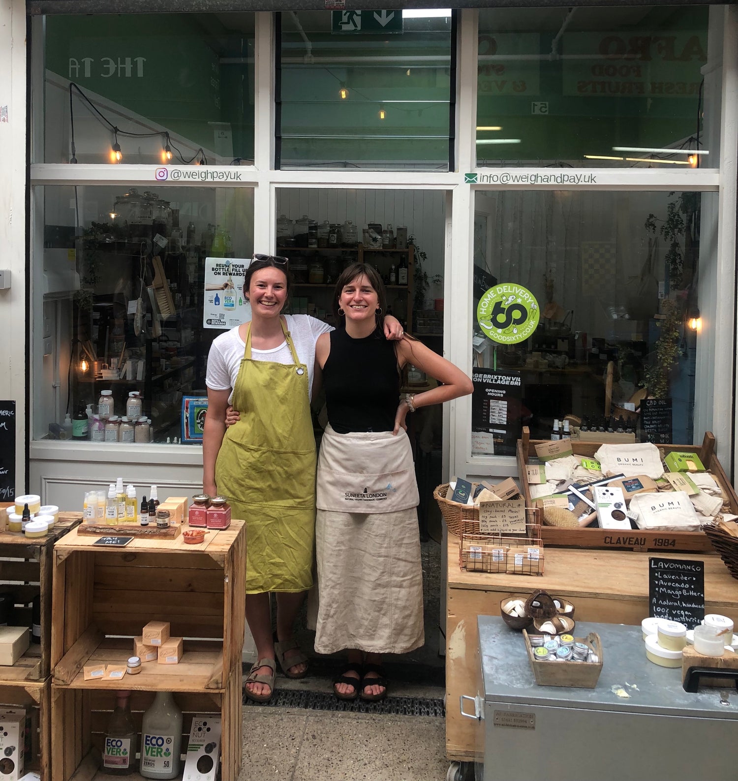 owner jennifer poust and staff in front of weigh and pay shop in brixton village, photo of two girls shopkeepers wearing aprons