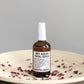 anti ageing argan oil serum in large glass pump container and rose petals, by suneeta London x weigh and pay