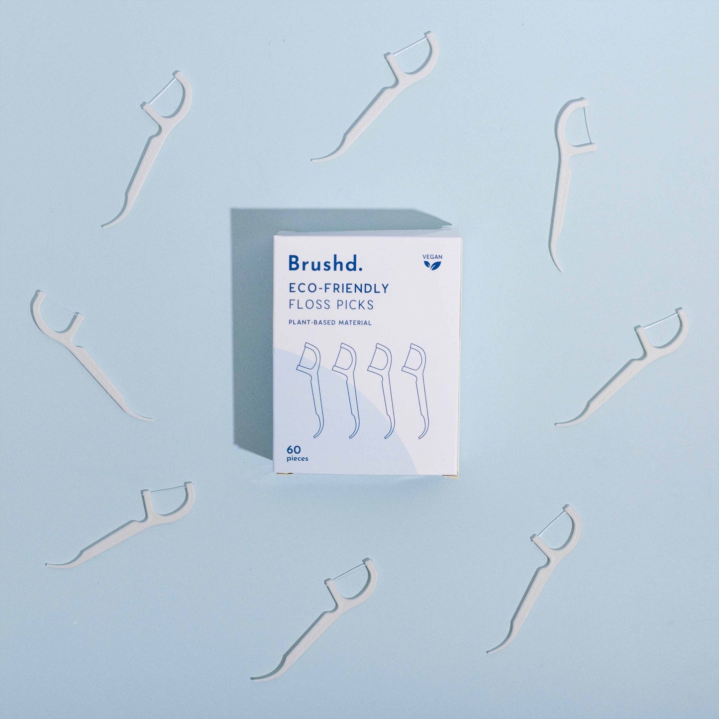 brushd eco friendly floss picks, blue background, birds eye view