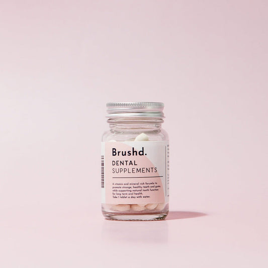 dental supplements in glass jar by brushd, pink background