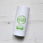 dew deodorant deo stick by elsa, white wooden background, birds eye view