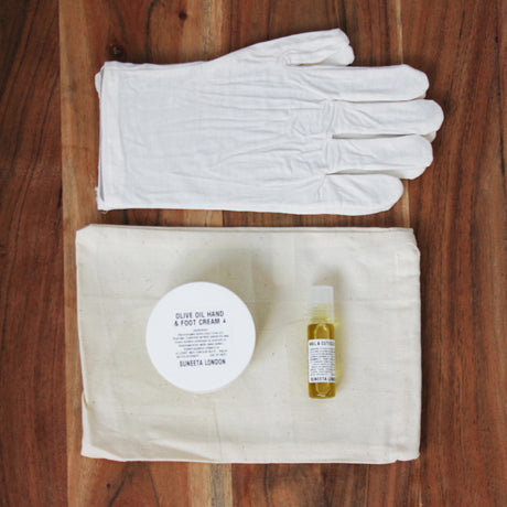 bamboo gloves on wooden table with hand cream and nail oil accessories, birds eye view